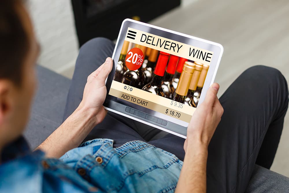 Man holding tablet to order alcohol during holiday